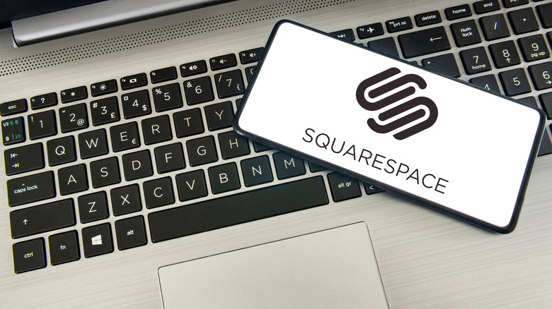 A smartphone laying on a laptop with the Squarespace logo.
