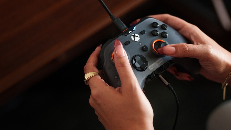 Woman with long nails holding a Scuf Valor Pro controller