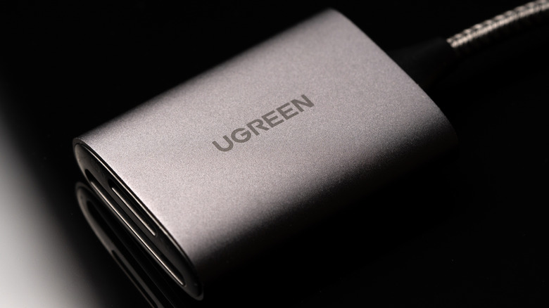 Close-up of UGREEN logo on a SD card reader against a black background
