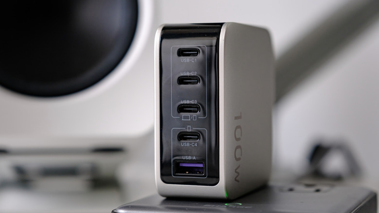 UGREEN X773 Nexode Pro 100W GaN charger with smart display shown during a desktop charging and technology setup session