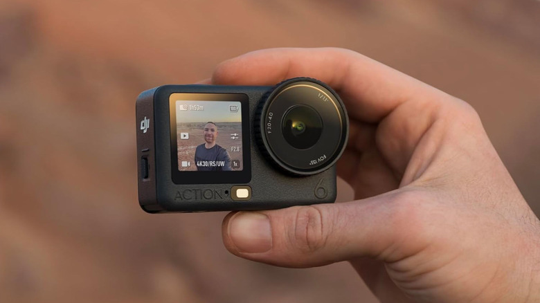 A hand holding the DJI Osmo Action 6