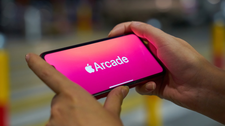 iPhone held in landscape with Apple Arcade logo on the screen