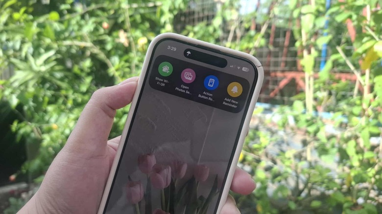Hand holding iPhone showing Shortcuts menu