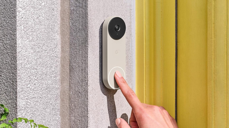 A hand ringing the Google Nest Doorbell (Wired, 2nd Gen).
