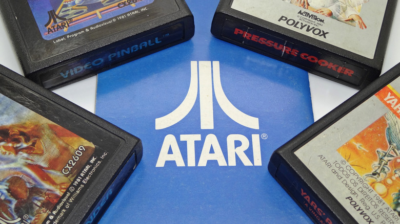 Several video game cartridges surrounding the Atari logo
