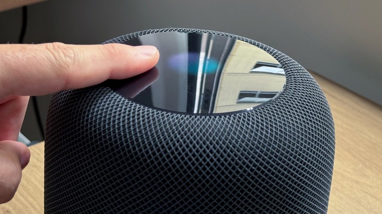 A finger touching the display of a HomePod
