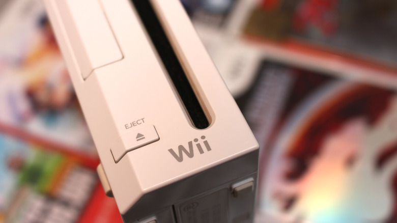 A close-up of the Nintendo Wii on a pile of games including Mortal Kombat.