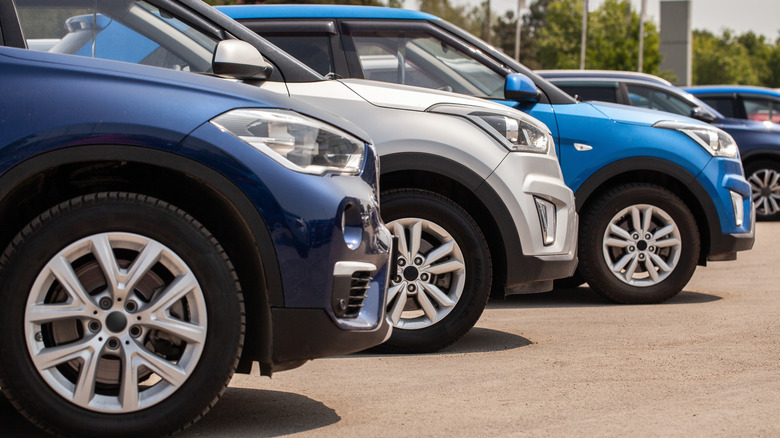 Row of compact SUVs parked side by side in outdoor dealership lot