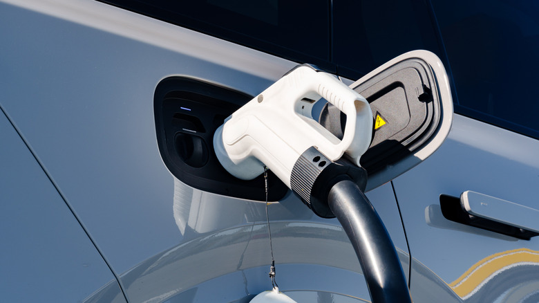 EV charging connector plugged into electric vehicle charging port during recharge session