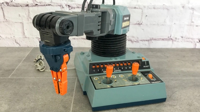 A vintage Armatron toy on a slate floor