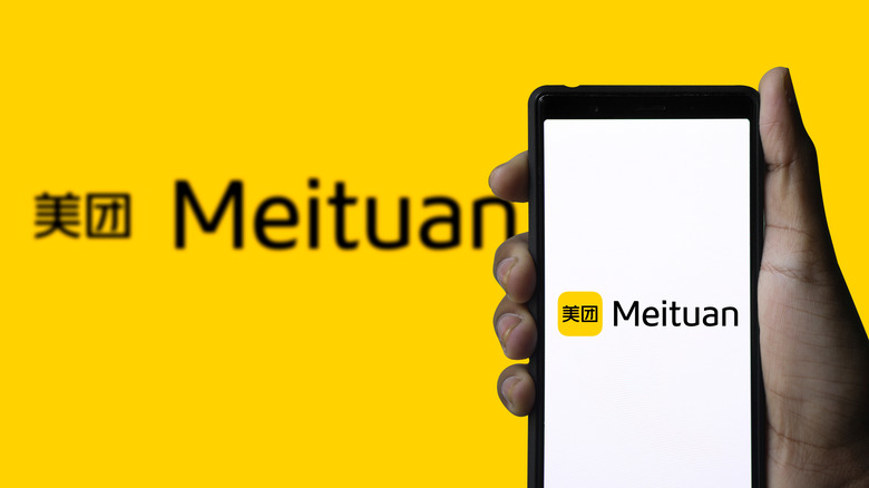 Meituan logo on phone screen stock image.