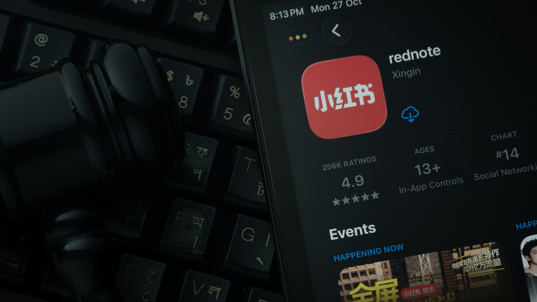 An iPad displaying the rednote app against a judge's gavel and dark keyboard background.