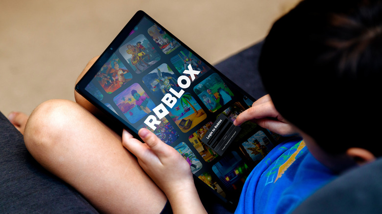 Child playing Roblox on a tablet.