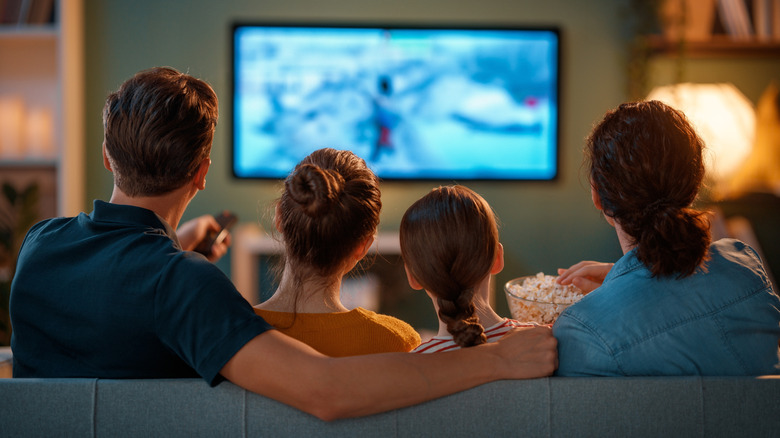 A family watching TV in the living room.