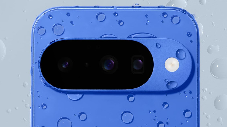 Close-up of a blue Google Pixel phone camera bar covered in water droplets.