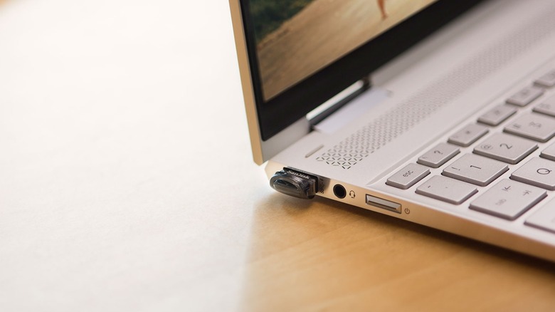 Close-up of a Sandish compact USB drive plugged into a laptop