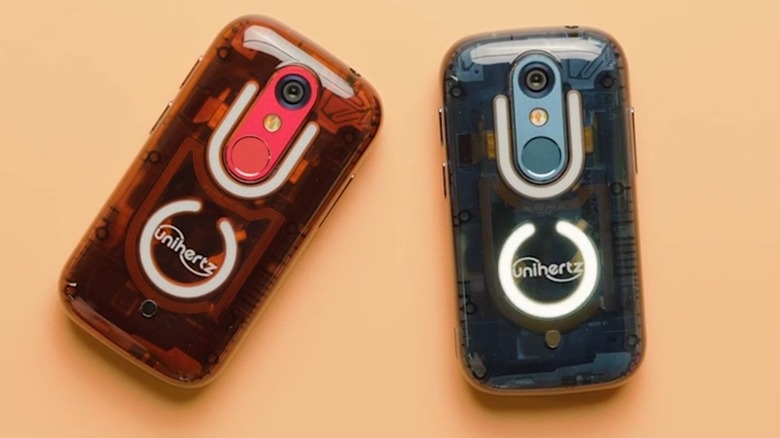 A translucent red and translucent blue Jelly Star smartphones sitting next to each other on a beige surface