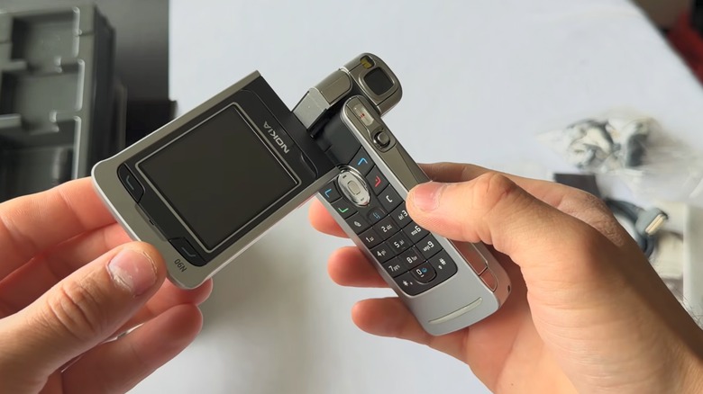 Person holding Nokia N90 camcorder cell phone
