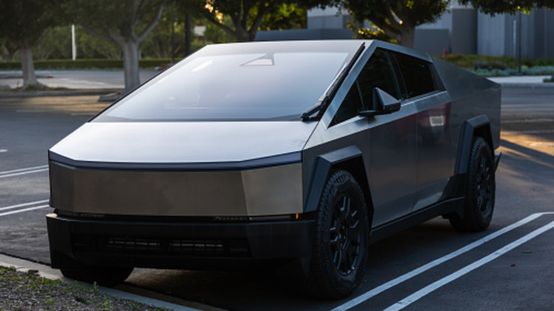 Tesla Cybertruck parked in a lot during daylight.