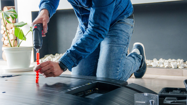 A person preparing a TV for wall mounting
