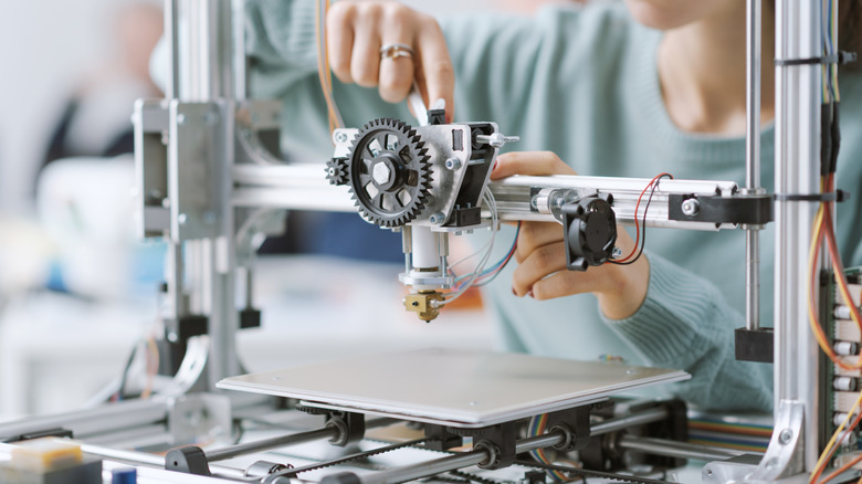 Person working with a 3D printer inside a lab