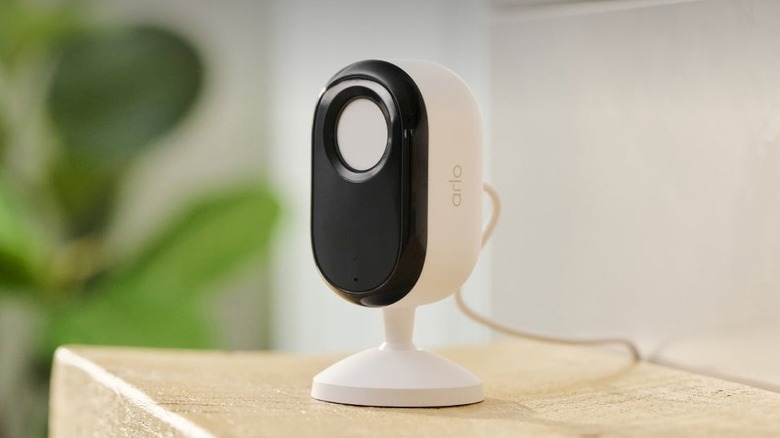 Arlo Essential Indoor Camera Plug-in VMC3070 placed on a wooden surface