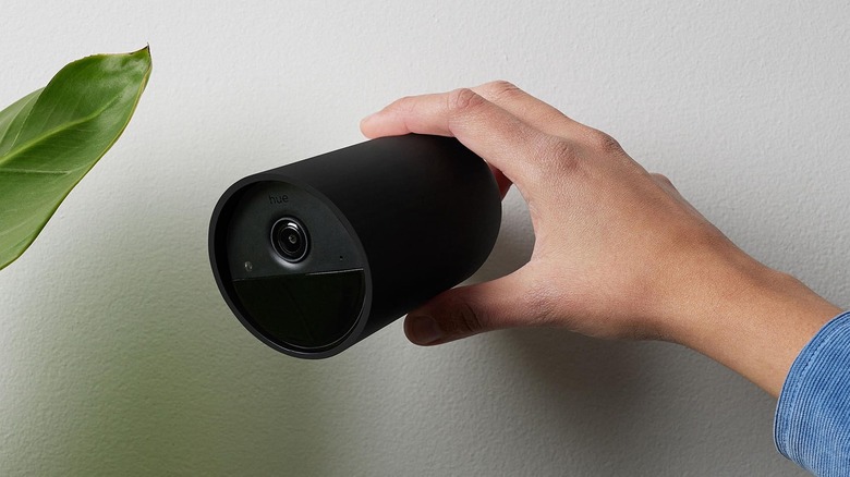 Close-up of a person installing the Phipils Secure Battery Camera on a wall
