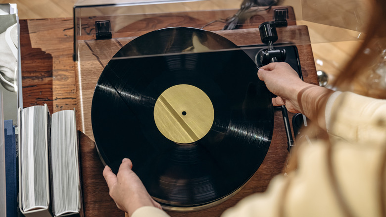 A person placing a vinyl record on a turntable.
