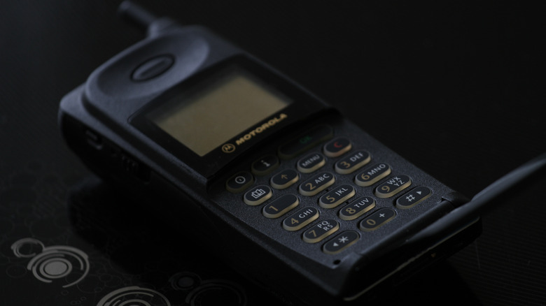 A Microtac phone with the cover open, exposing the dial pad.
