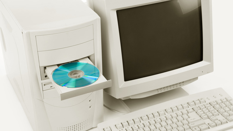 An old computer setup with a CD on the disk tray.