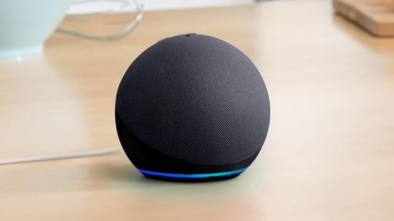 Amazon Echo Dot 5th generation with a blue light ring sitting on a desk.