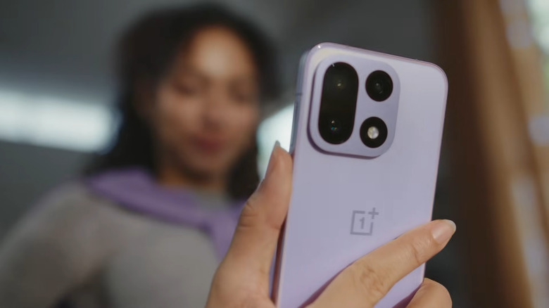 Woman holding OnePlus phone in purple