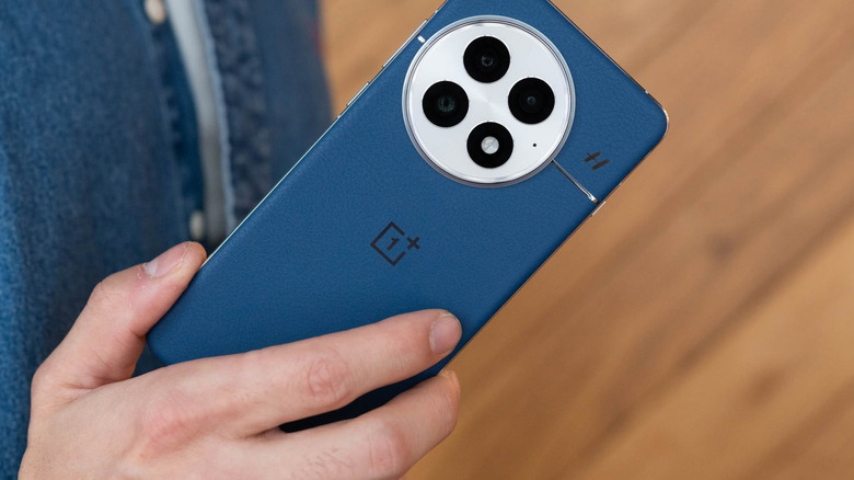 OnePlus 13 showing blue rear of phone and camera bump, held in hand