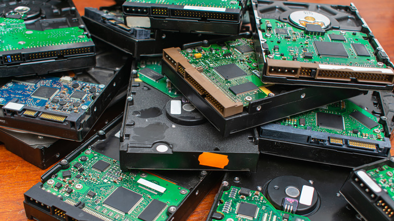 A pile of hard disk drives on a table