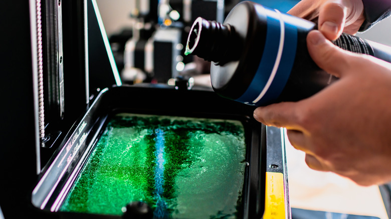 Liquid resin being poured into a 3D resin printer