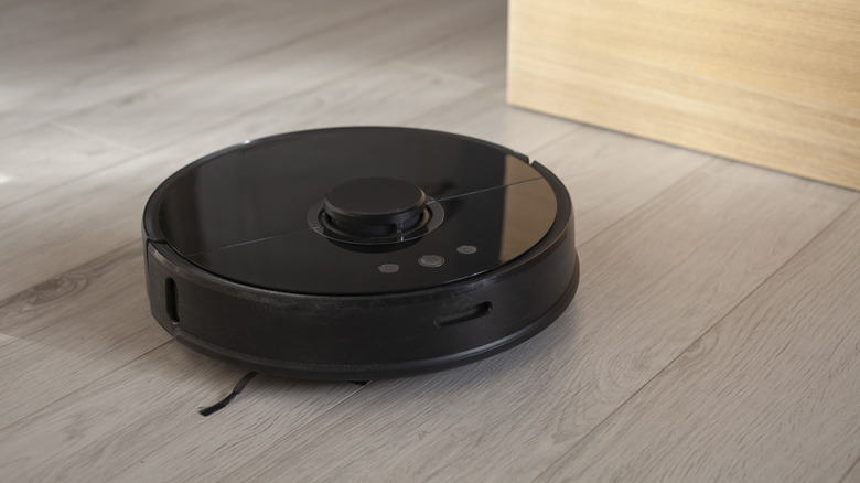 A robotic vacuum cleaning a hardwood floor