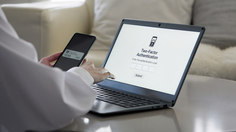 A man entering a 2-factor authentication code on a laptop