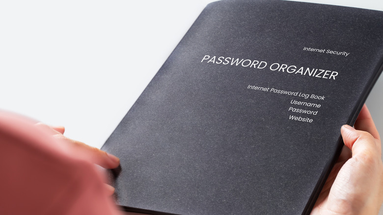 Someone holding a black password log book