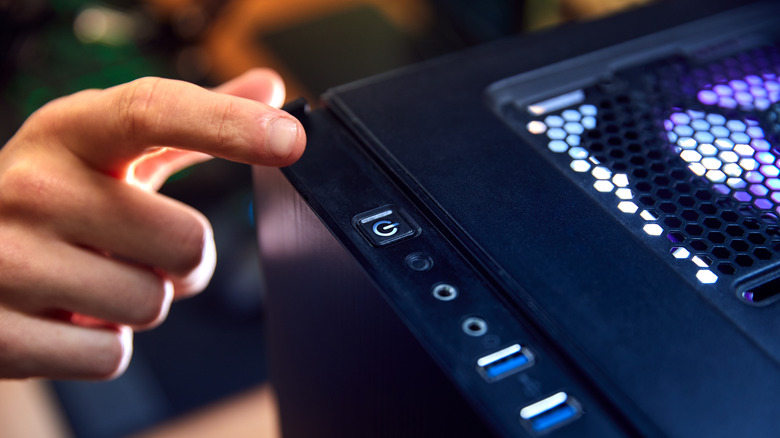 Finger about to press power button on PC