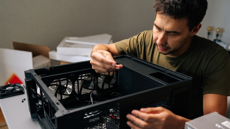 Man works on open PC case