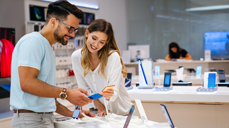 A couple looking at phones for sale.