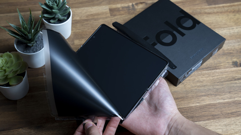 Samsung foldable phone with a protective film being peeled from the inner screen.
