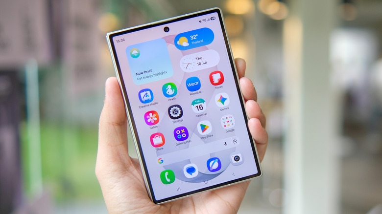 Samsung foldable phone held open with the inner display and app icons visible.