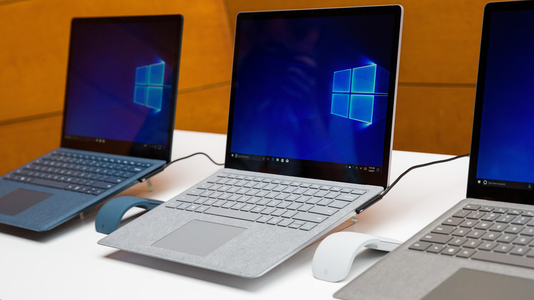 Several Microsoft Surface Laptops lined up on a desk.