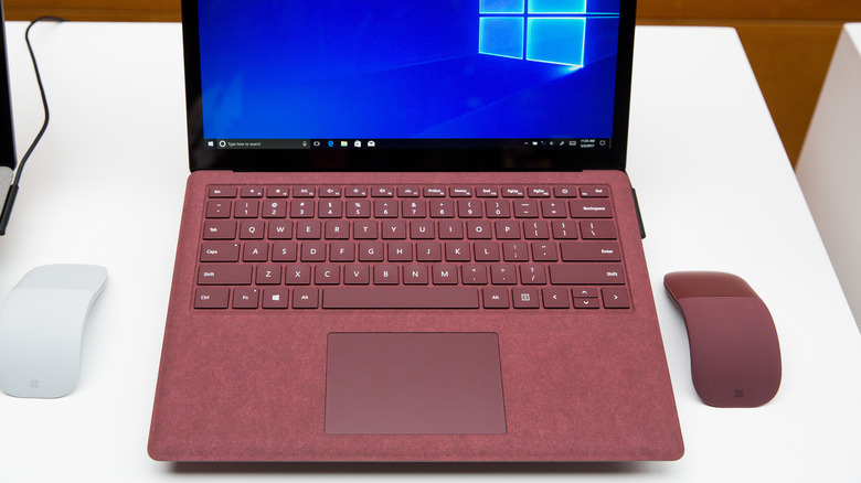Closeup of red Microsoft Surface Laptop and mouse.