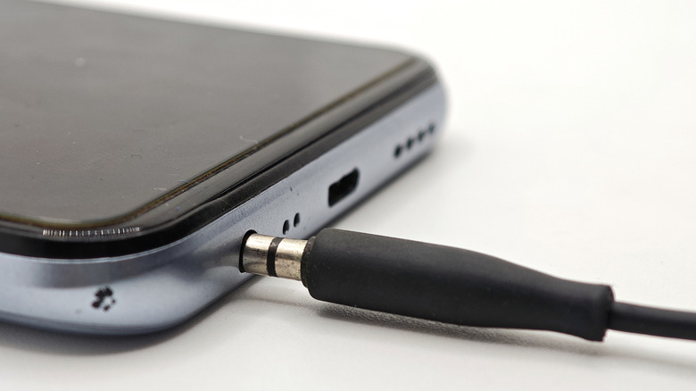 Close-up of a 3.5mm headphone jack plugged into a smartphone.