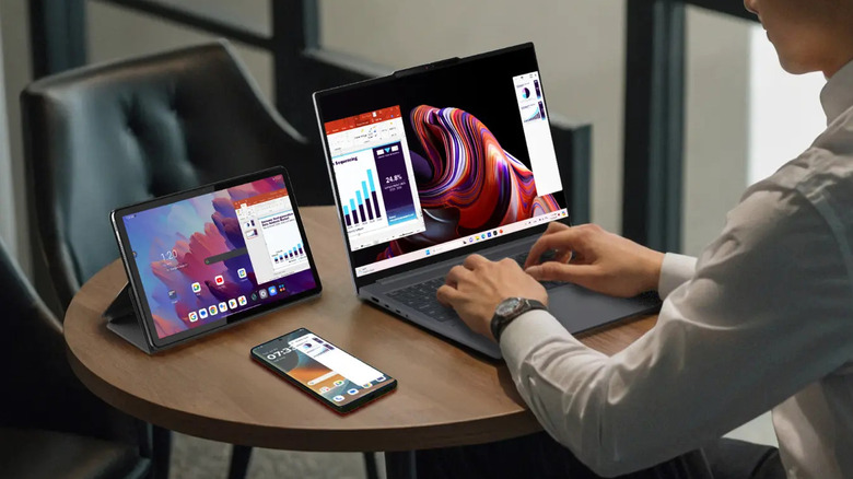 Motorola Smart Connect running across a laptop, tablet, and phone as a person works at a table.