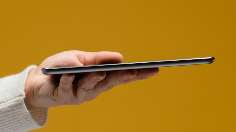 Person holding an extremely thin tablet