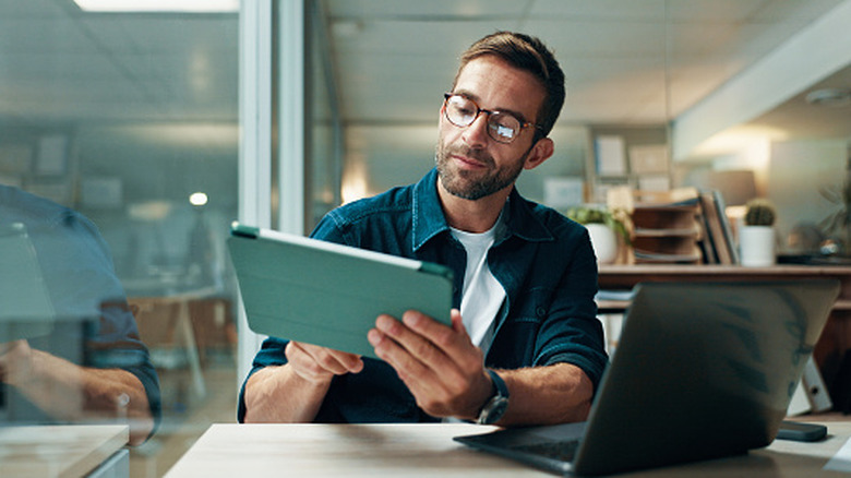 Person using a tablet at a desk