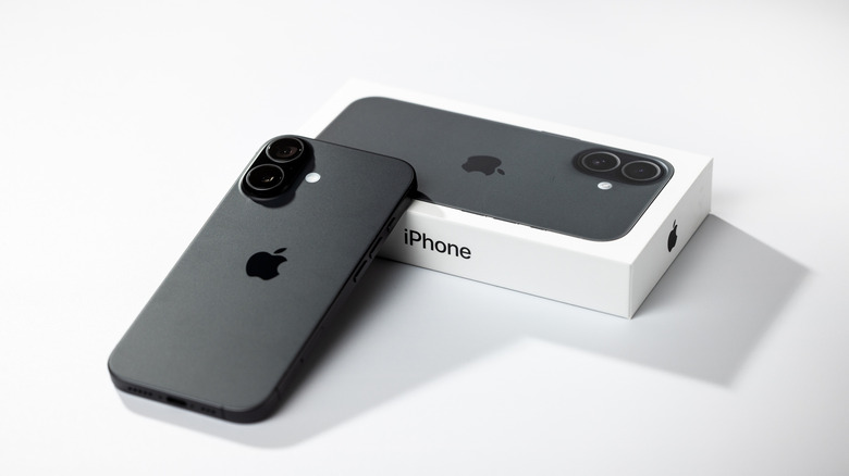 apple iPhone 17 next to its packaging placed on a white table